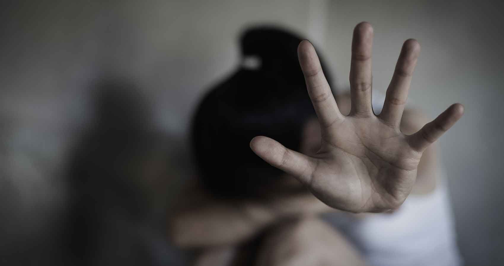 A woman is covering her face with her hand.