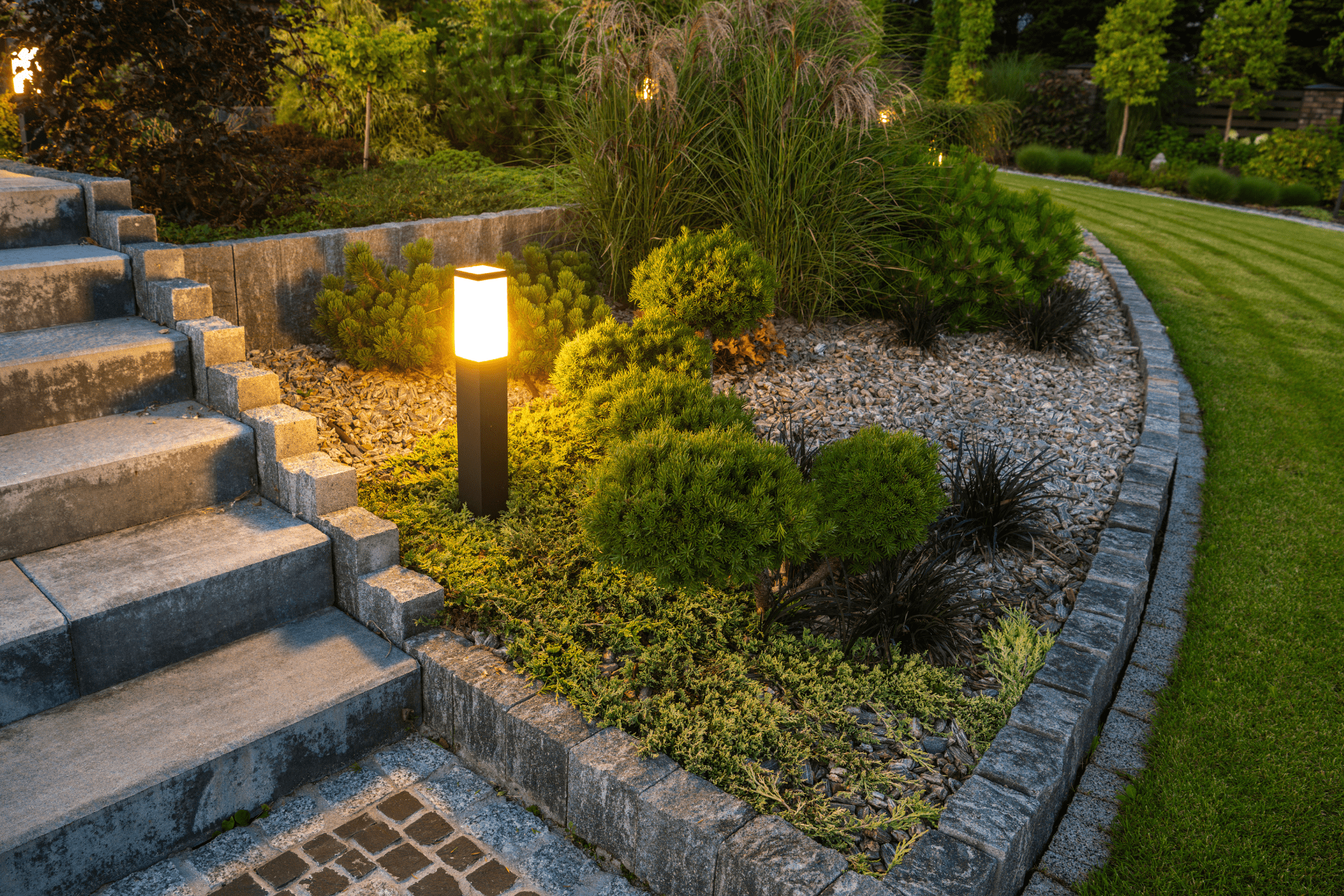 A bollard light used to illuminate the area near the steps in a backyard