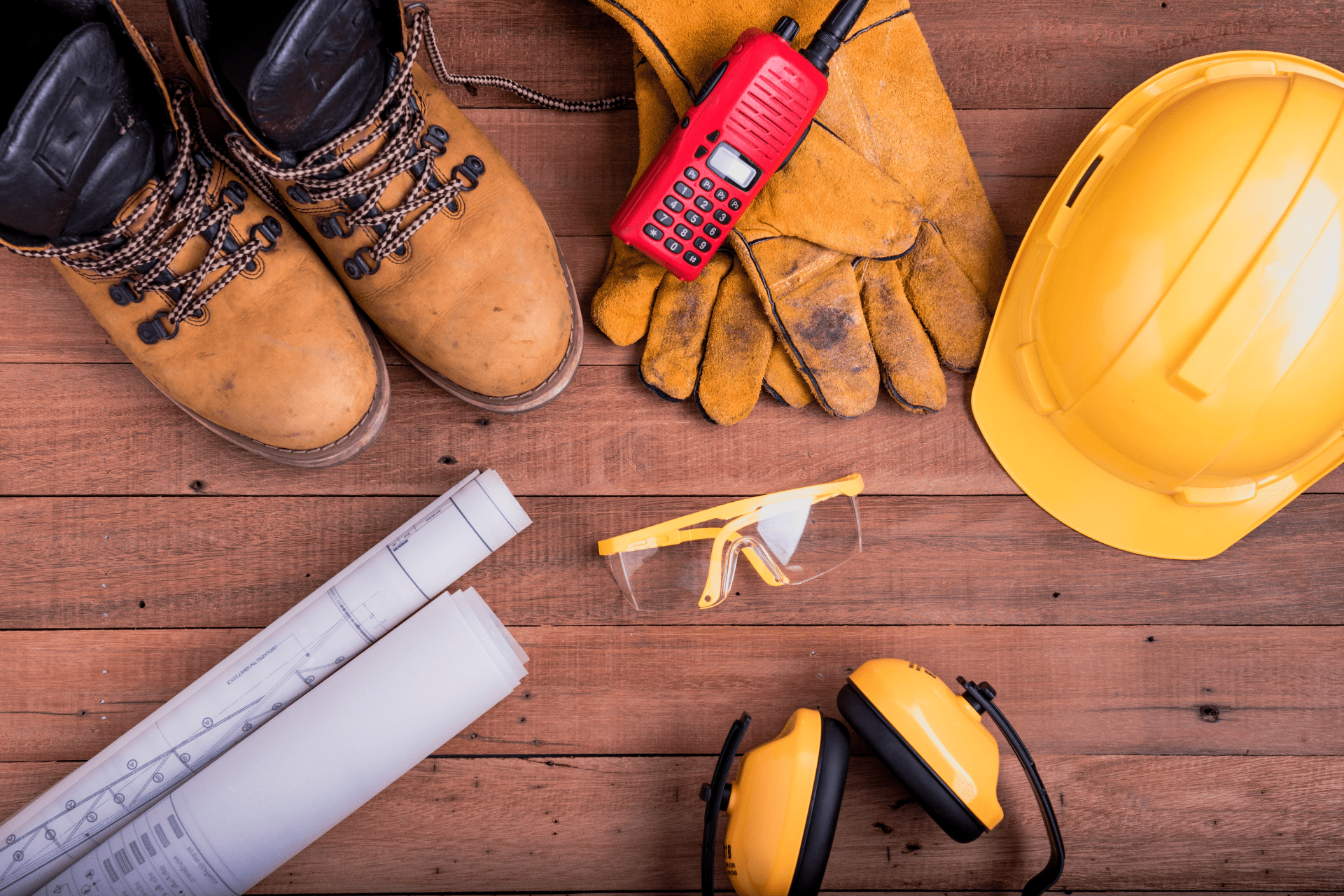 Safety gear for landscaping. Helmet, gloves, safety glasses, earmuffs, and boots