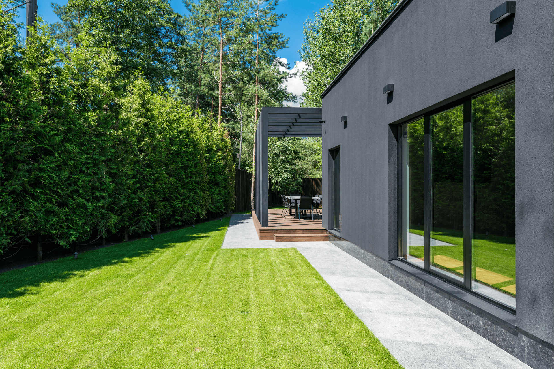 Modern landscape with a porch, lawn, and trees for privacy screens