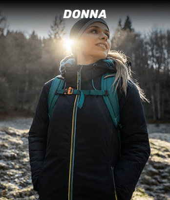 A woman wearing a black jacket and a blue backpack is standing in a field.