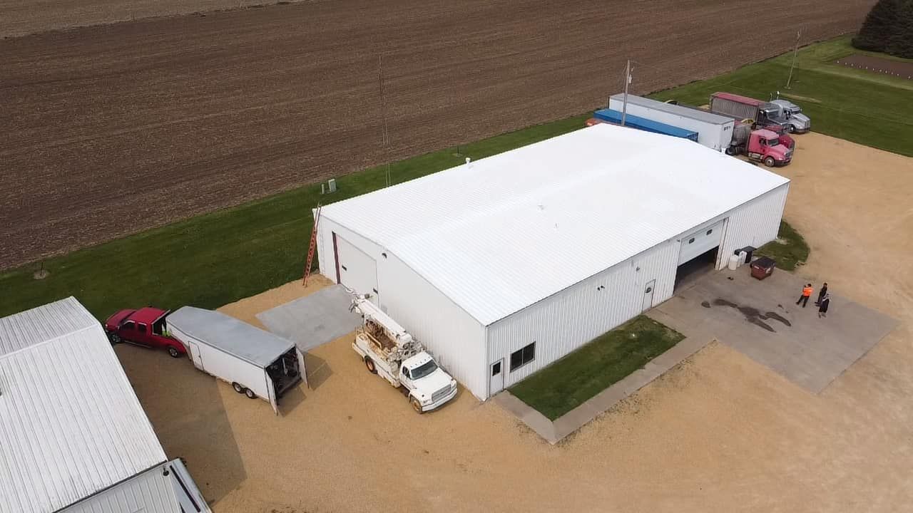 An aerial view of a large white building with a truck parked in front of it.
