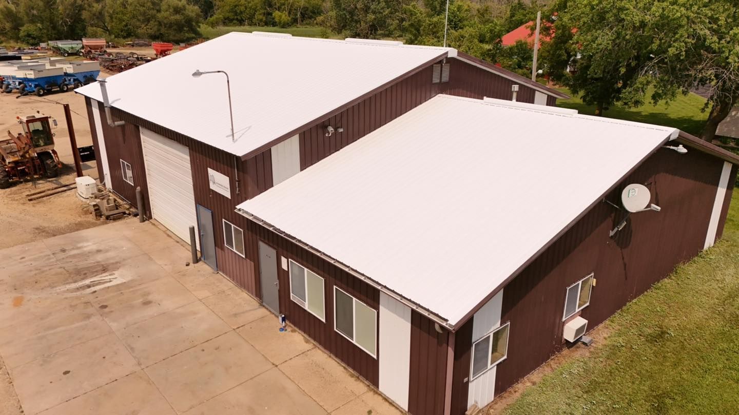 An aerial view of two buildings with a white roof.