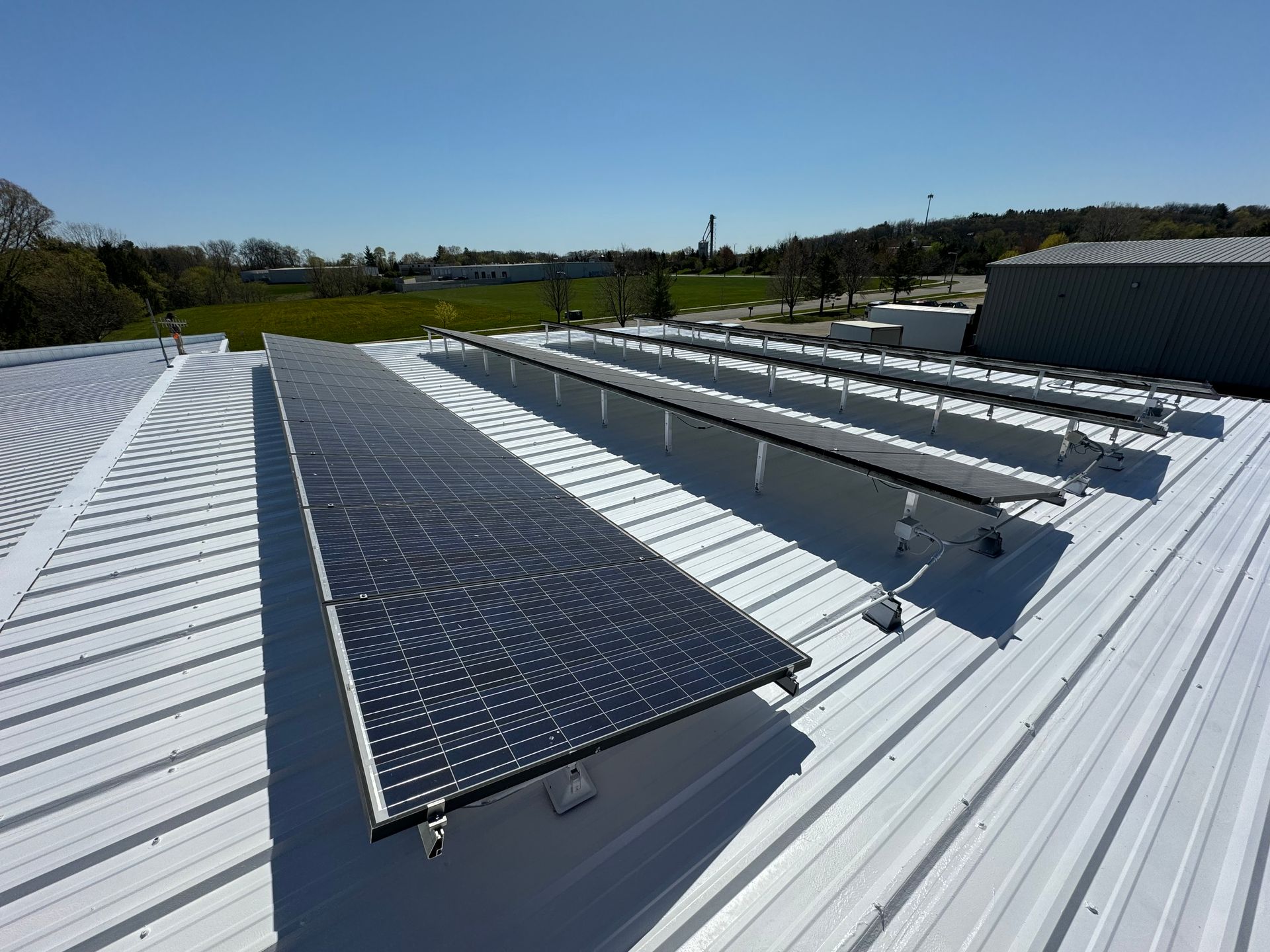 A row of solar panels on a white roof