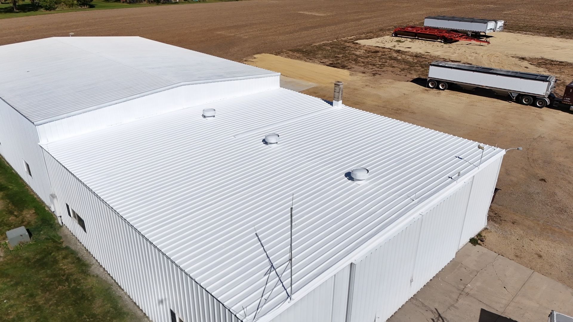 An aerial view of a large white building with a white roof.