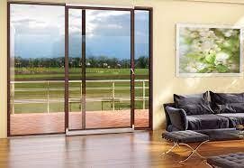 Porte scorrevoli in vetro che si affacciano su un campo verde; interno con divano e opere d'arte.