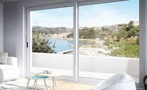 Ampie porte scorrevoli in vetro offrono una vista panoramica sulla baia e sulla città. L'interno è arredato con divani e poltrone bianchi.