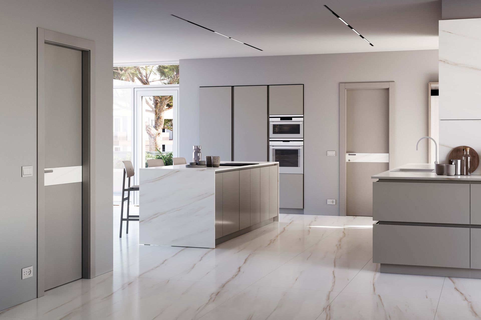 Cucina moderna con mobili grigi, isola in marmo e pavimento chiaro. Due porte a vista.
