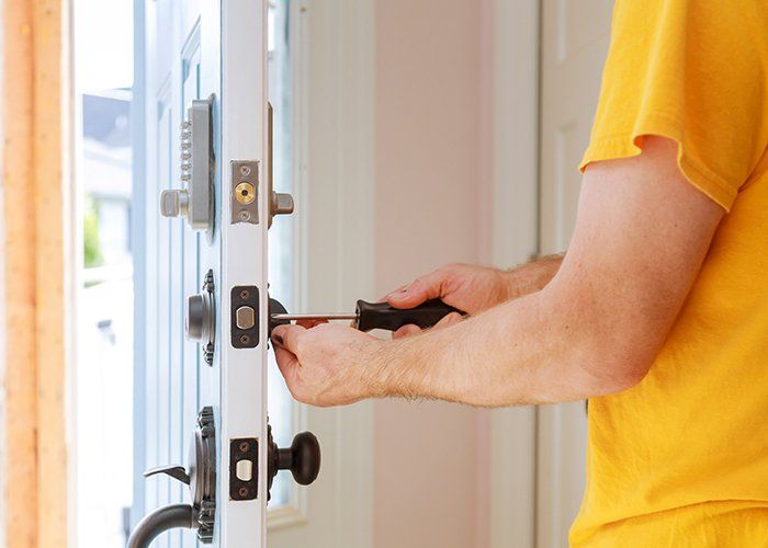 Door Replacement — Worker Installing Lock In Pompano Beach, FL Door Replacement — Worker Installing Lock In Pompano Beach, FL