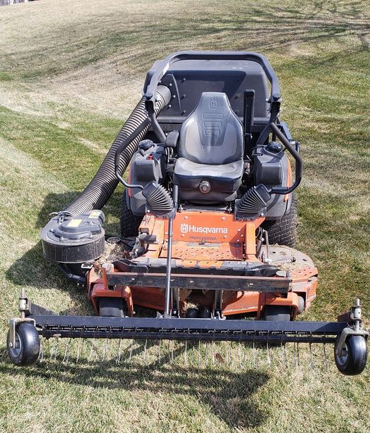 a lawn mower is sitting on top of a lush green yard .