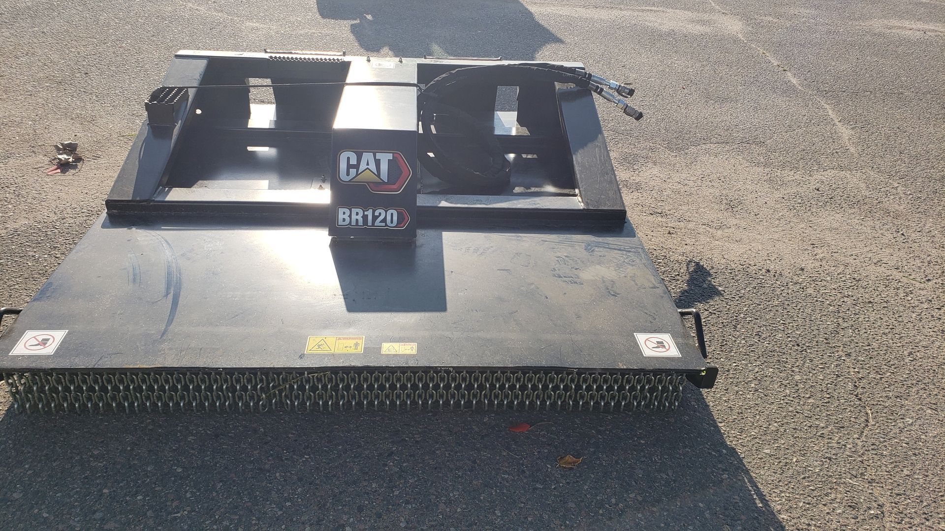 a dumpster filled with wood chips and a green blower .