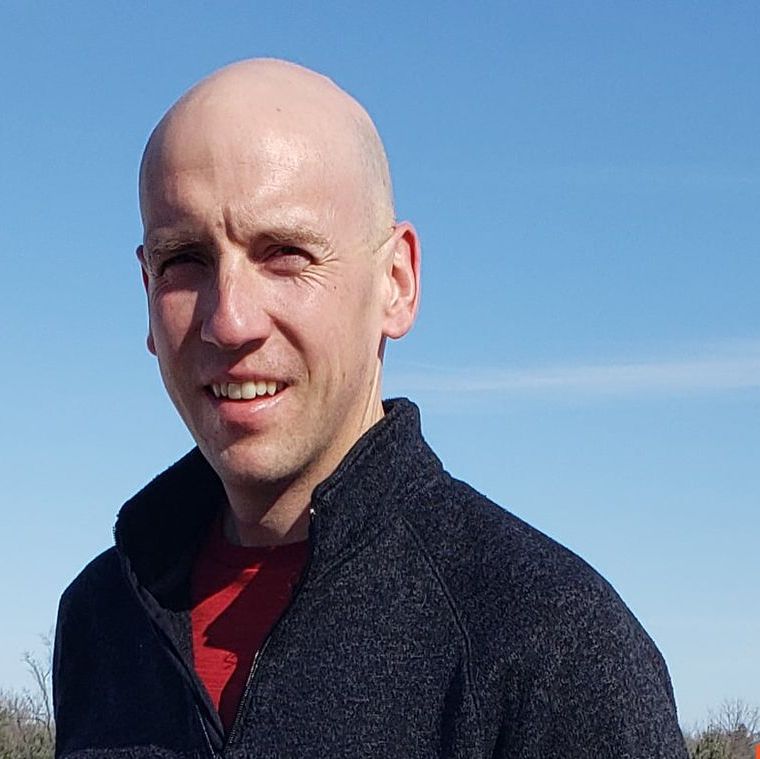 Hoese Enterprises owner Nicholas Hoese is wearing a black jacket and a red shirt is smiling for the camera .