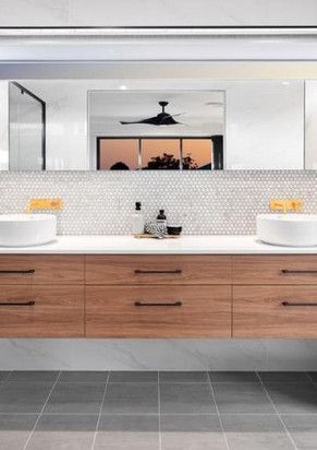 A bathroom with two sinks and a large mirror.