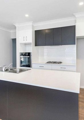 A kitchen with a stove, sink, and oven.