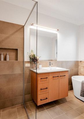A bathroom with a sink, mirror, tub and walk in shower.
