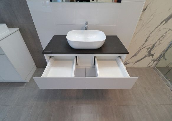 A bathroom with a sink and drawers underneath it.