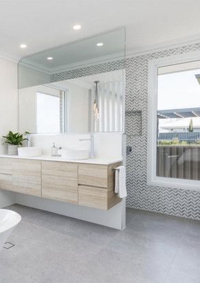 A bathroom with two sinks, a toilet, and a large mirror.
