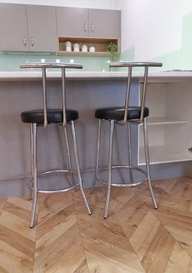 Two bar stools are sitting next to each other in a kitchen.