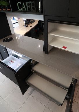 A kitchen with a refrigerator and a drawer open.