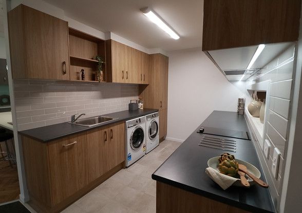 A kitchen with a washer and dryer and a sink.