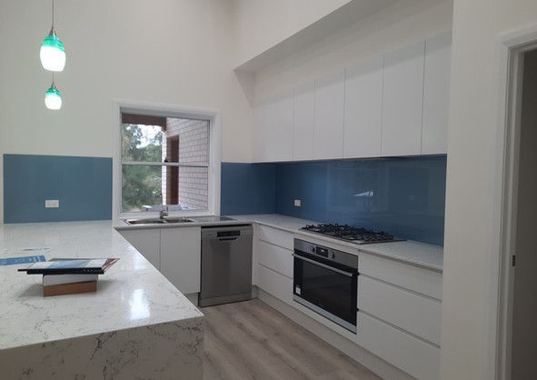 A kitchen with white cabinets and blue counter tops.