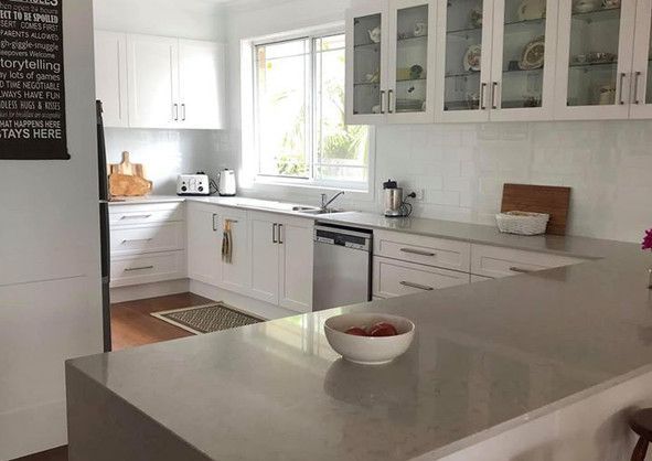 A kitchen with white cabinets and a bowl of food on the counter.