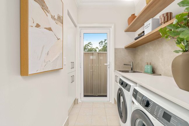 A laundry room with a washer and dryer and a sink.