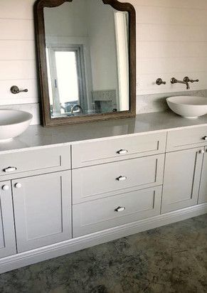 A bathroom vanity with two sinks and a mirror.