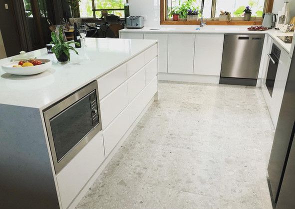 A kitchen with white cabinets and stainless steel appliances.