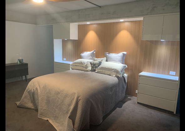 A bedroom with a bed, dresser and nightstand.