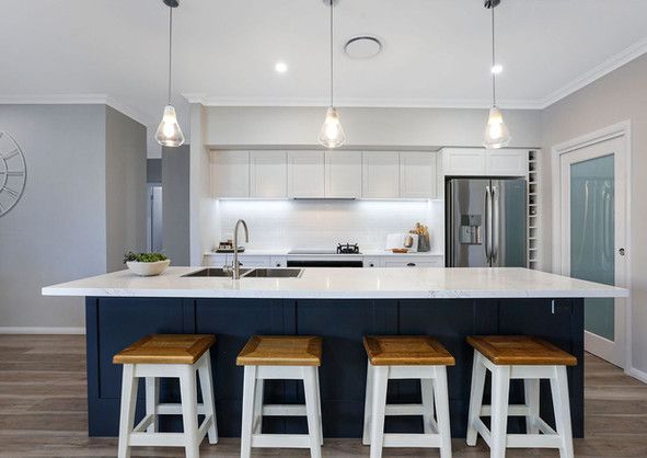 A kitchen with a large island and stools.