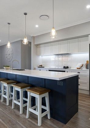 A kitchen with a large island and stools, as viewed from the side.