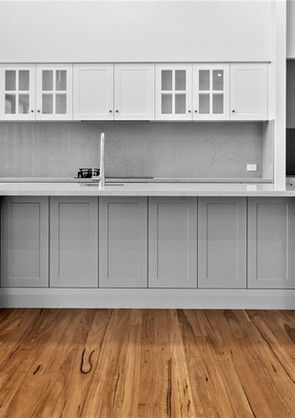 A kitchen with gray cabinets and a wooden floor.