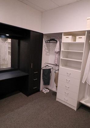 A walk in closet with lots of shelves and drawers and a mirror.