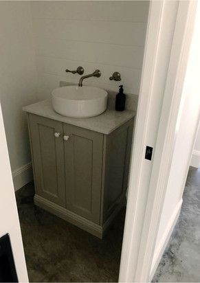 A bathroom with a sink and a soap dispenser on the counter.
