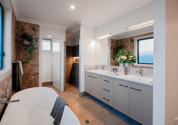 A bathroom with a bathtub, sinks, and a window.