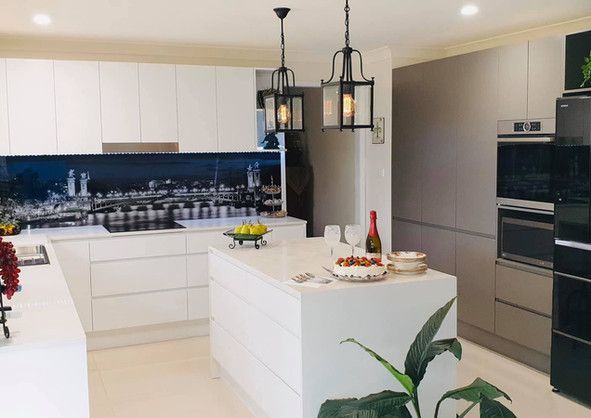A kitchen with white cabinets and a large island in the middle.