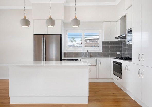 A kitchen with white cabinets and stainless steel appliances.