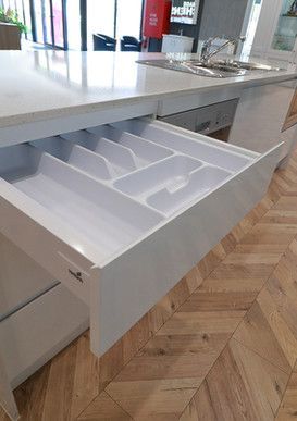 A kitchen with a drawer open filled with cutlery.
