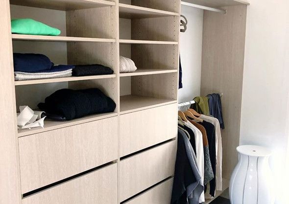 A walk in closet with lots of shelves and drawers filled with clothes.