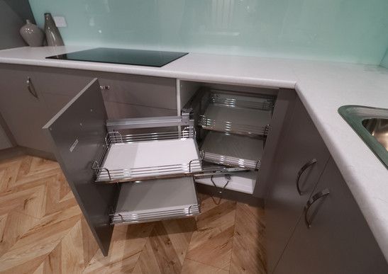 A kitchen with a pull out drawer and a stove top oven.