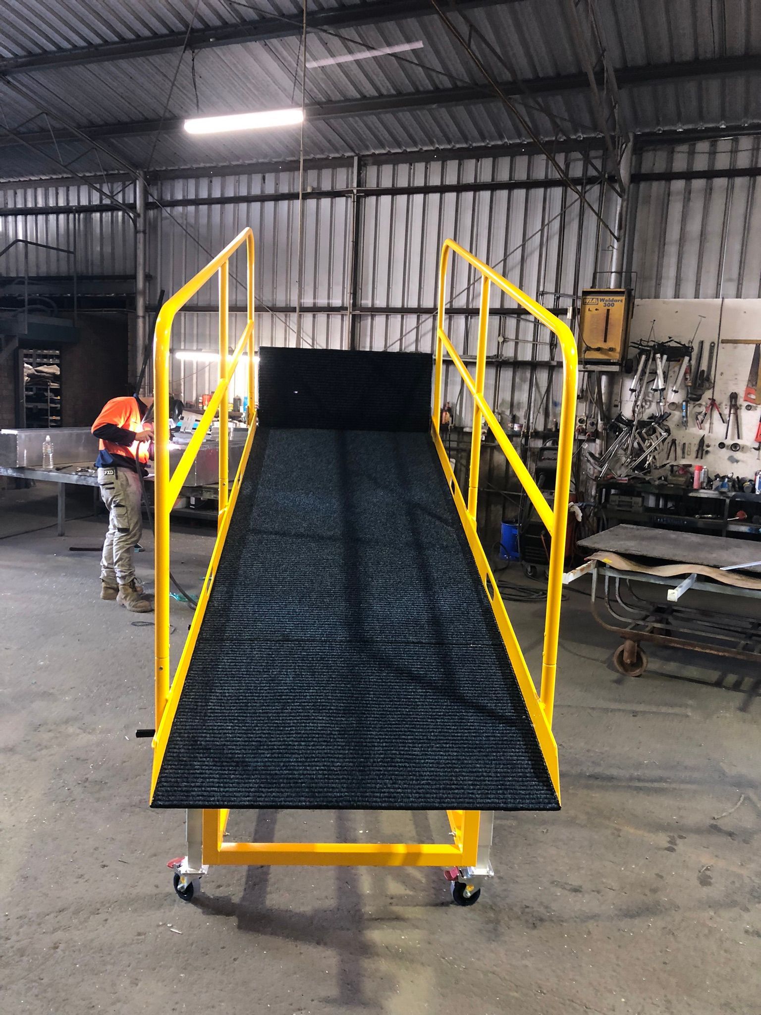 Yellow Ramp With Handrails And A Textured Black Surface — Soward Steel & Aluminium Fabrication in South Lismore, NSW