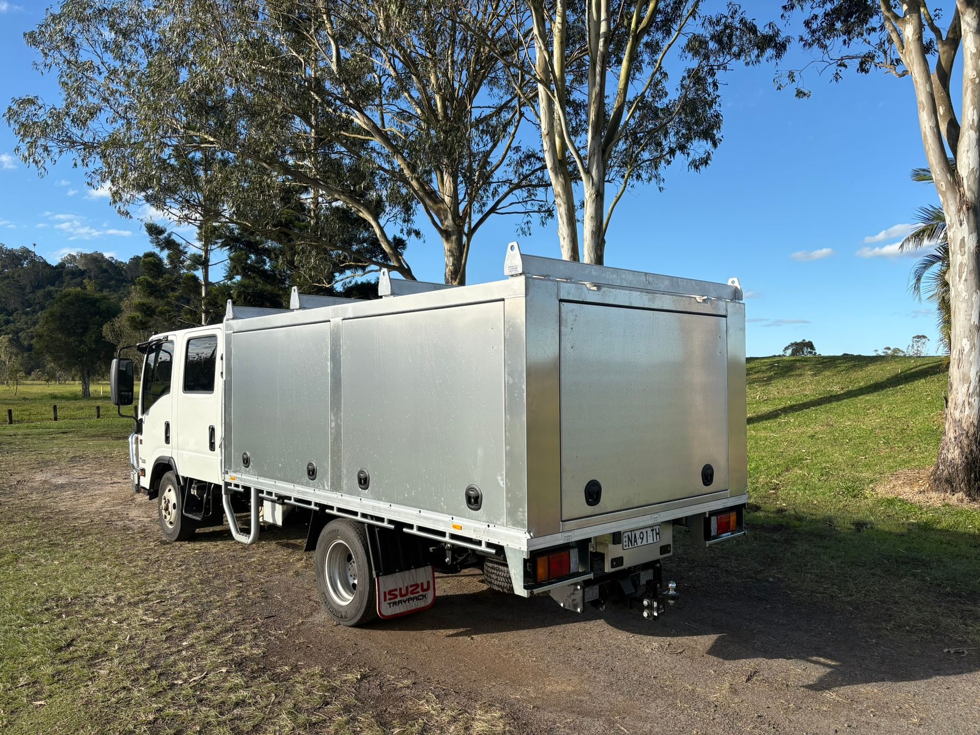 A Utility Truck With Closed Side Compartments Parked On Grass — Soward Steel & Aluminium Fabrication in South Lismore, NSW