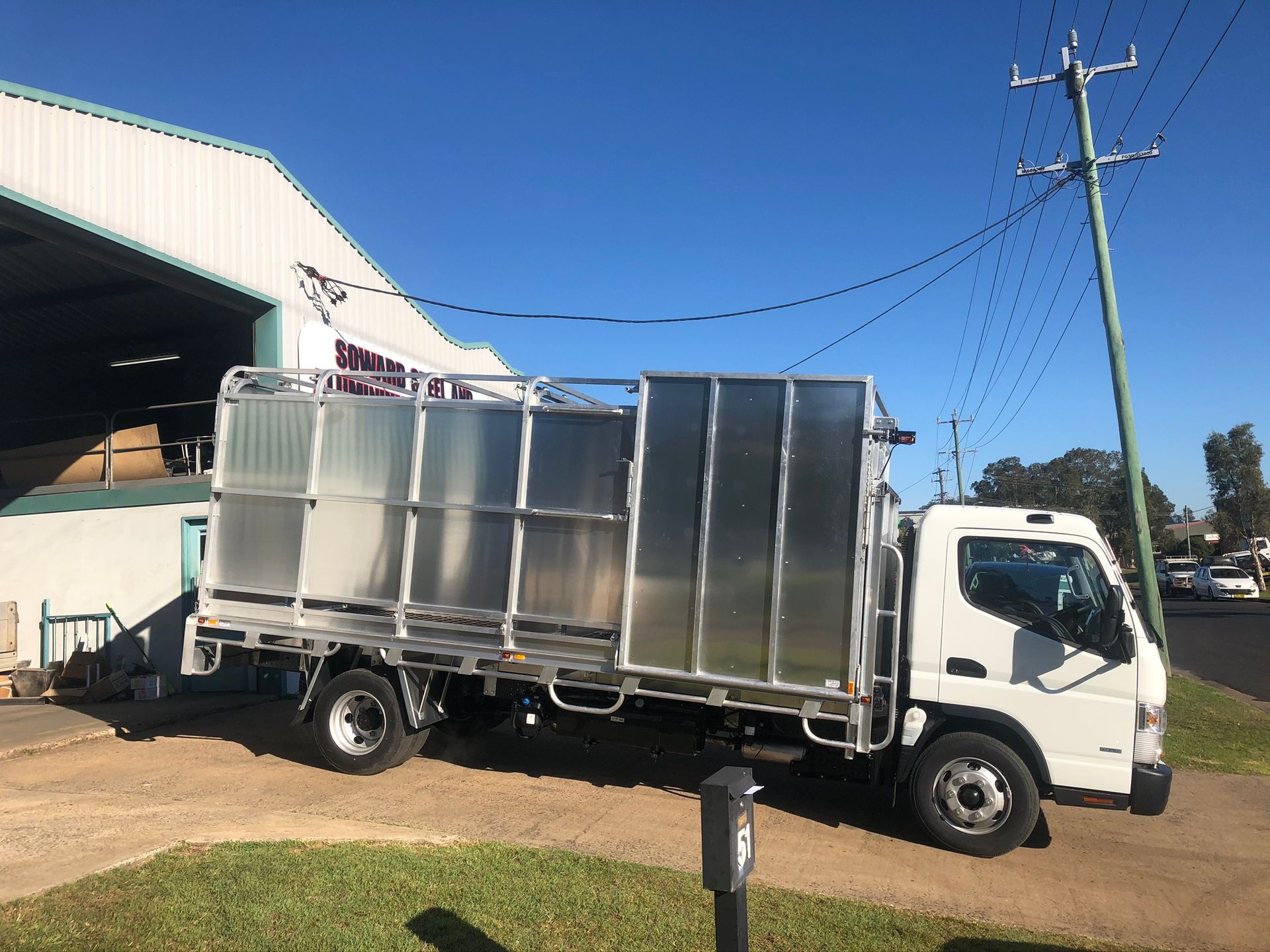 White Truck With A Caged Cargo Area Parked On A Driveway — Soward Steel & Aluminium Fabrication in South Lismore, NSW