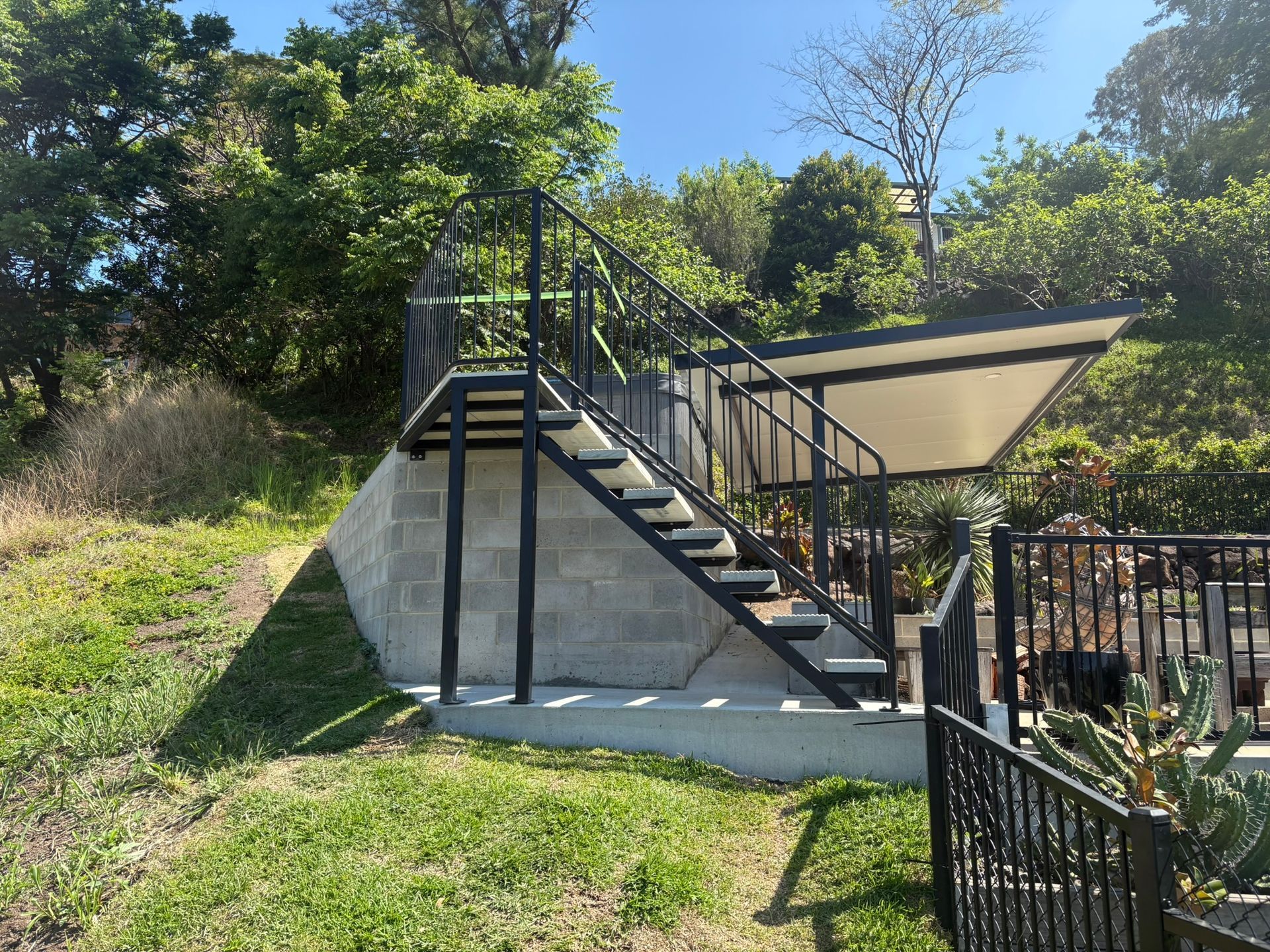 Metal Staircase With Black Railings Against Brick Walls — Soward Steel & Aluminium Fabrication in South Lismore, NSW