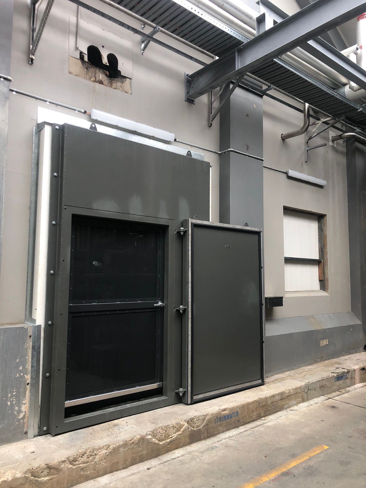 Metal Doors On A Gray Industrial Building — Soward Steel & Aluminium Fabrication in South Lismore, NSW