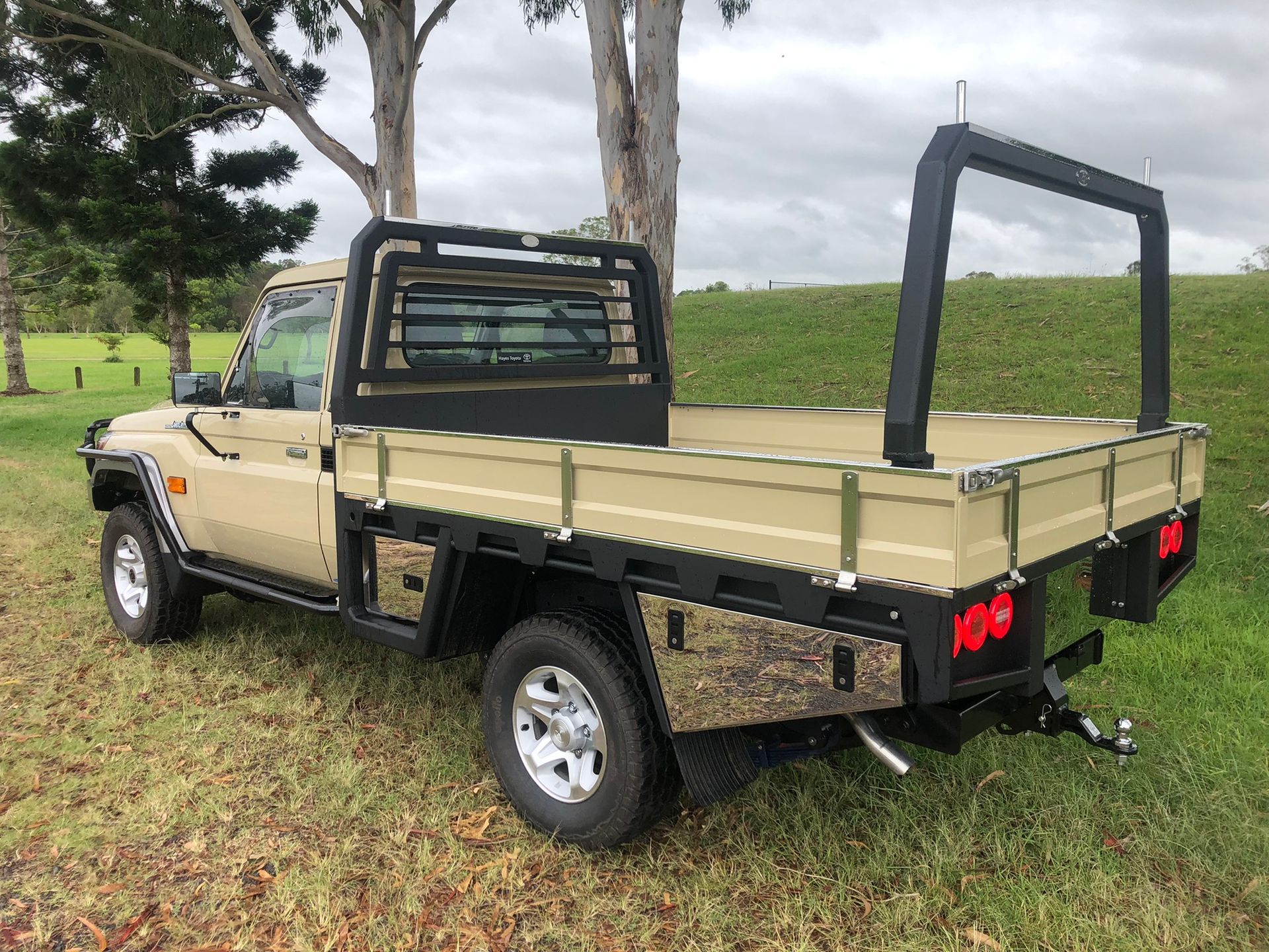 Tan Pickup Truck With A Flatbed In A Grassy Field — Soward Steel & Aluminium Fabrication in South Lismore, NSW