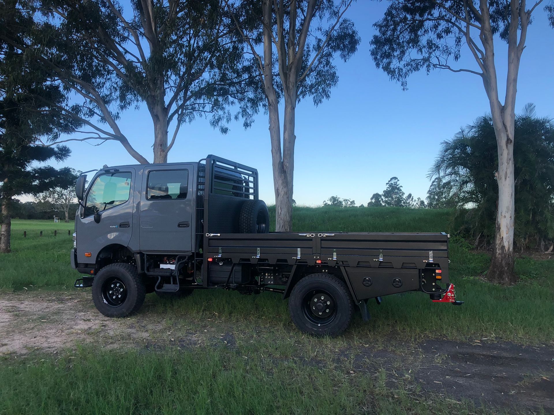 Gray Flatbed Truck Parked On Grass, Trees In The Background — Soward Steel & Aluminium Fabrication in South Lismore, NSW