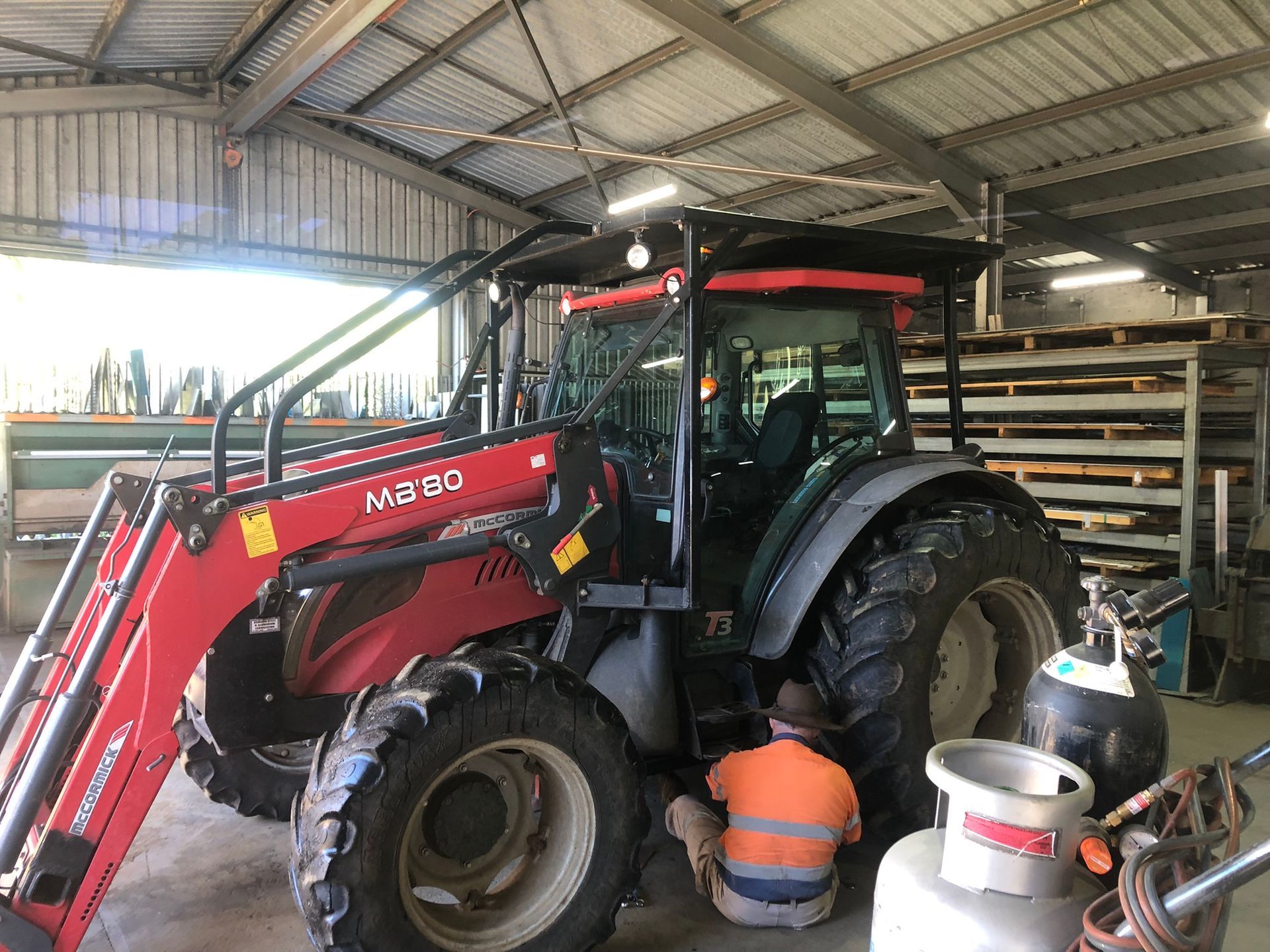 Red Tractor With Front Loader Inside A Workshop — Soward Steel & Aluminium Fabrication in South Lismore, NSW