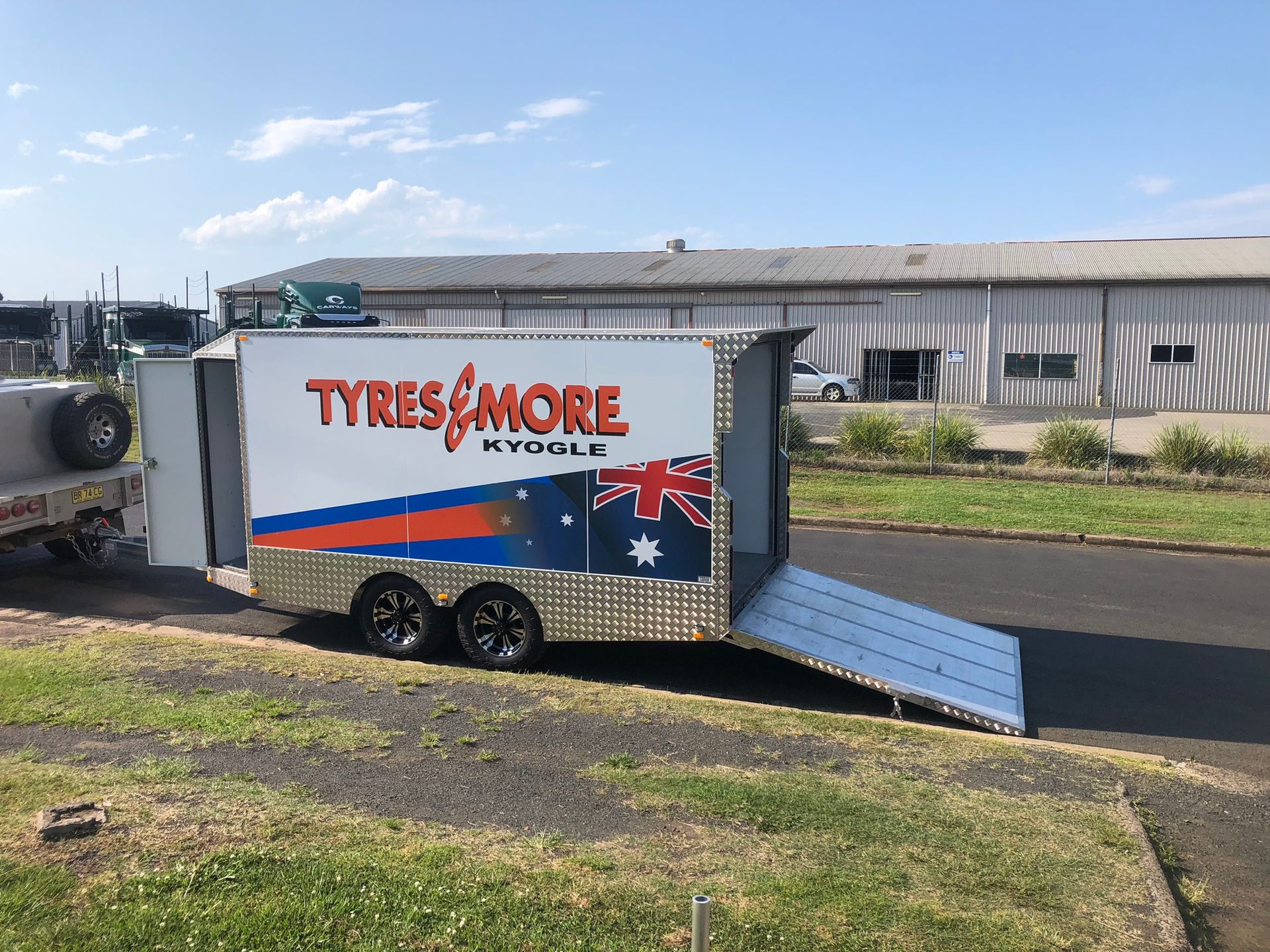 Silver Car Trailer With Ramps, Parked Outdoors on Pavement — Soward Steel & Aluminium Fabrication in South Lismore, NSW